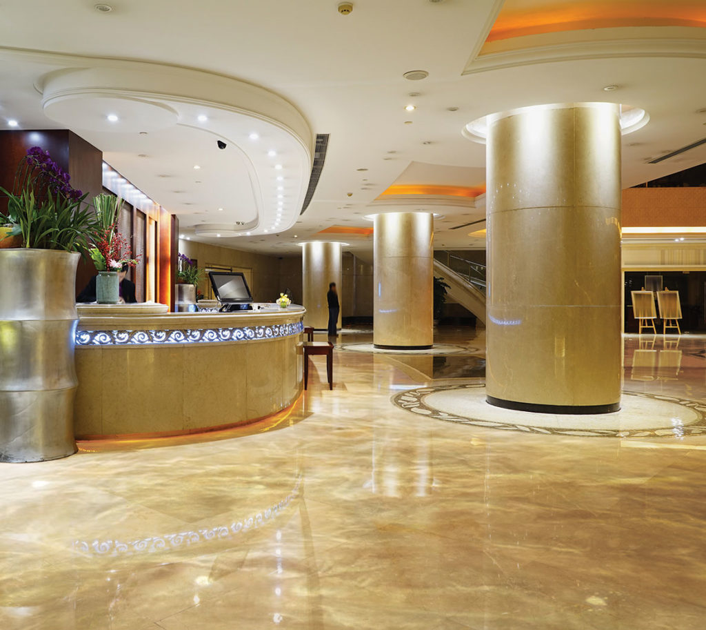 The lobby area of a hotel with a polished marble floor.