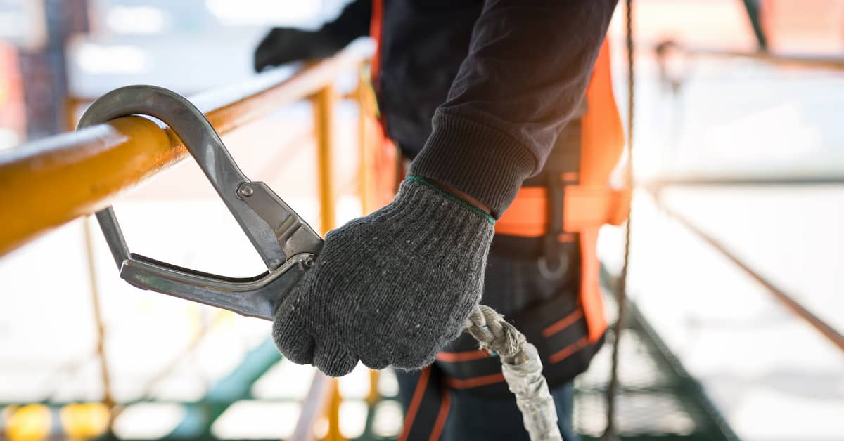 A worker is holding a rope on a construction site.