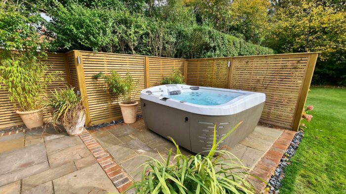 Backyard hot tub oasis with a wooden fence.