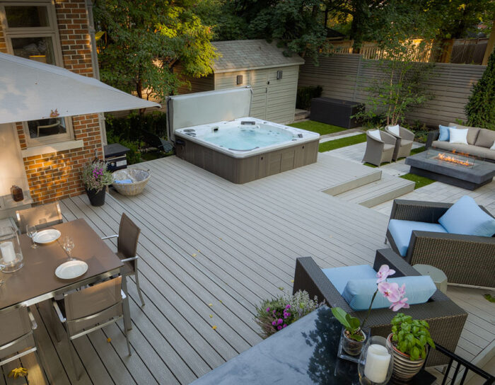 A backyard featuring a luxurious hot tub and comfortable patio furniture.