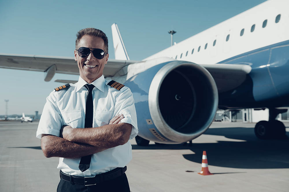 A traveling pilot in front of an airplane.