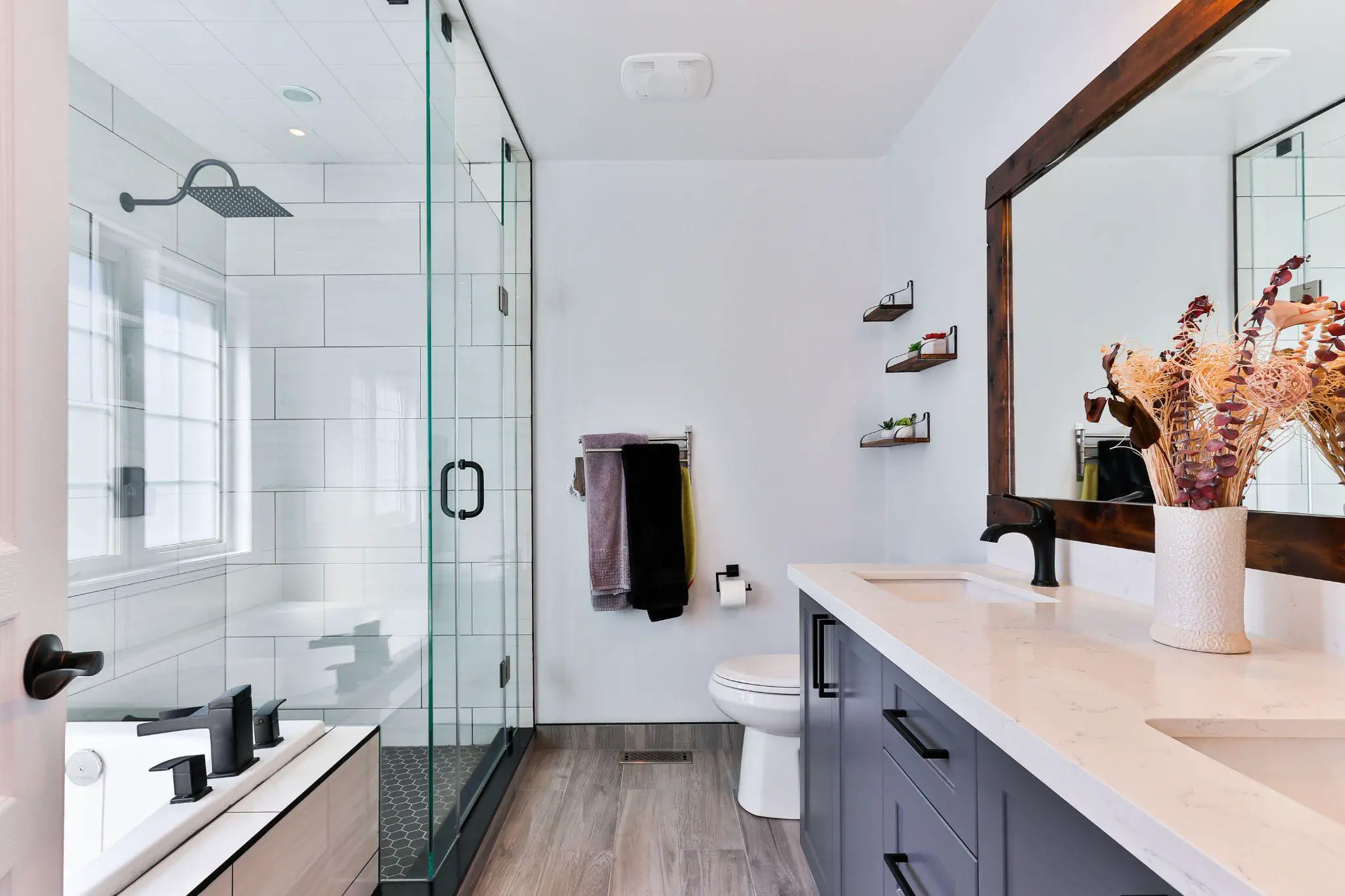 A modern bathroom with a glass shower and sink that enhances the value of your home.