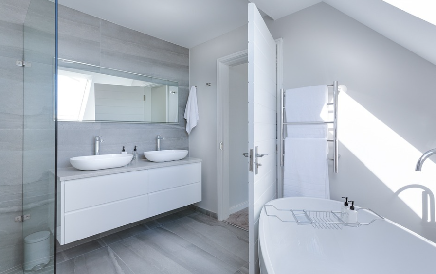 A modern bathroom with a white bathtub and sink undergoing Bathroom Remodeling.