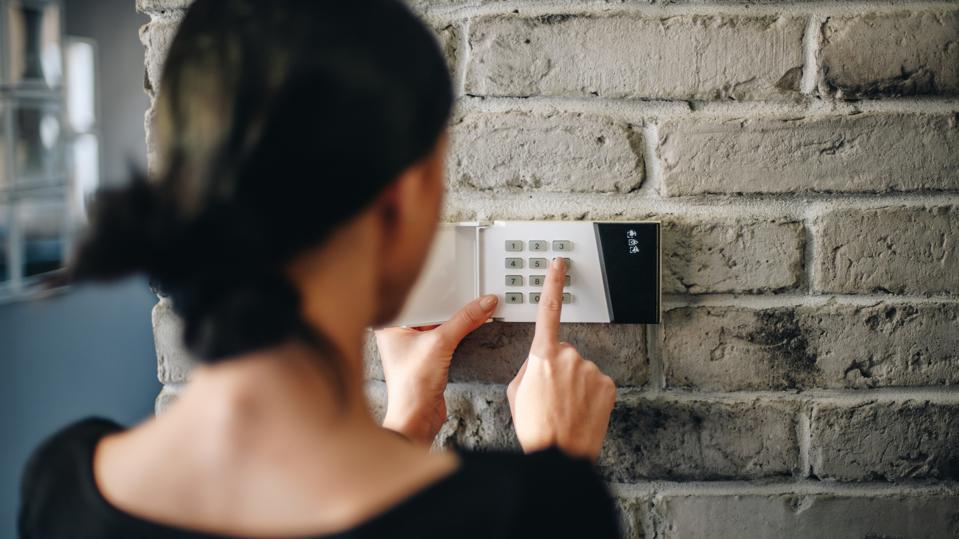 A woman activating a security system.