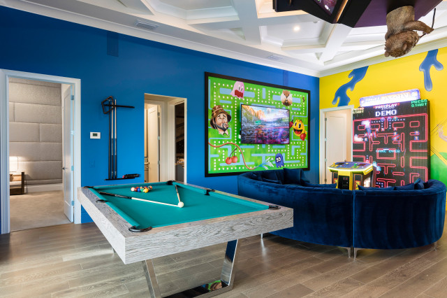 An entertainment room with a pool table and video games.
