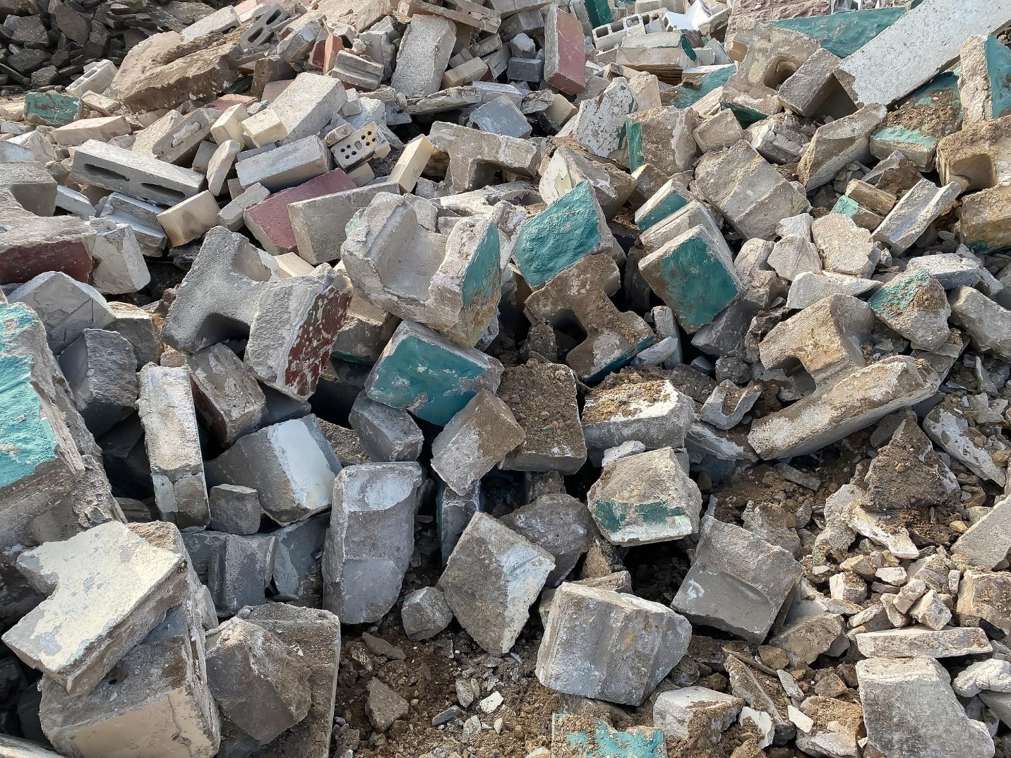 A pile of bricks in a pile of dirt used for construction purposes.