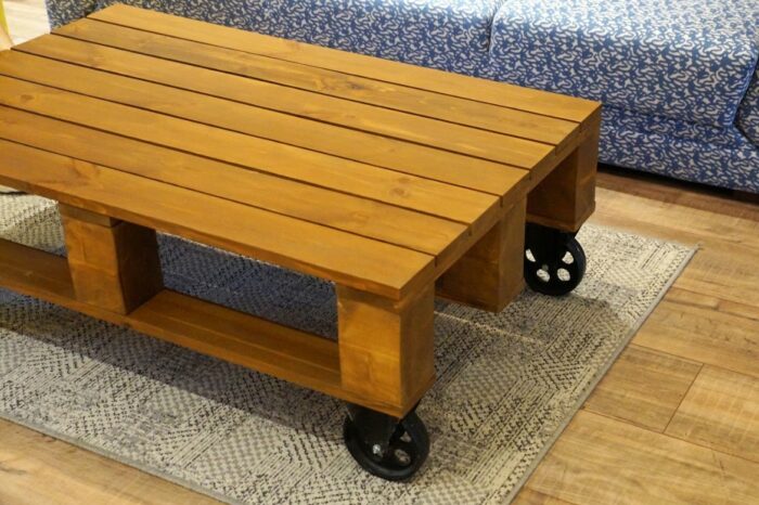A wooden pallet coffee table on wheels.