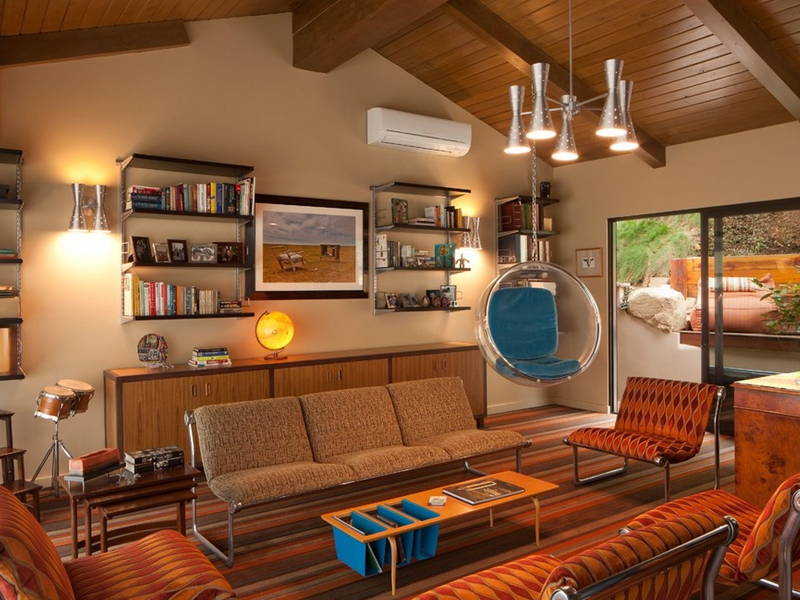 A retro living room with couches, chairs, and a bookcase, showcasing 70's interior design.