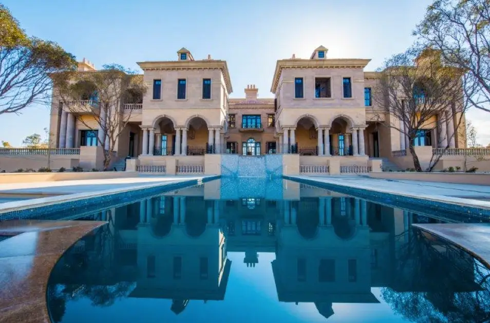 A large mansion with a pool in front of it, belonging to billionaire Douw Steyn.