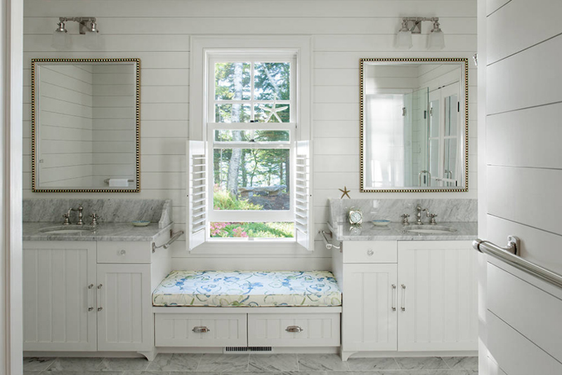 A white bathroom with a window seat.