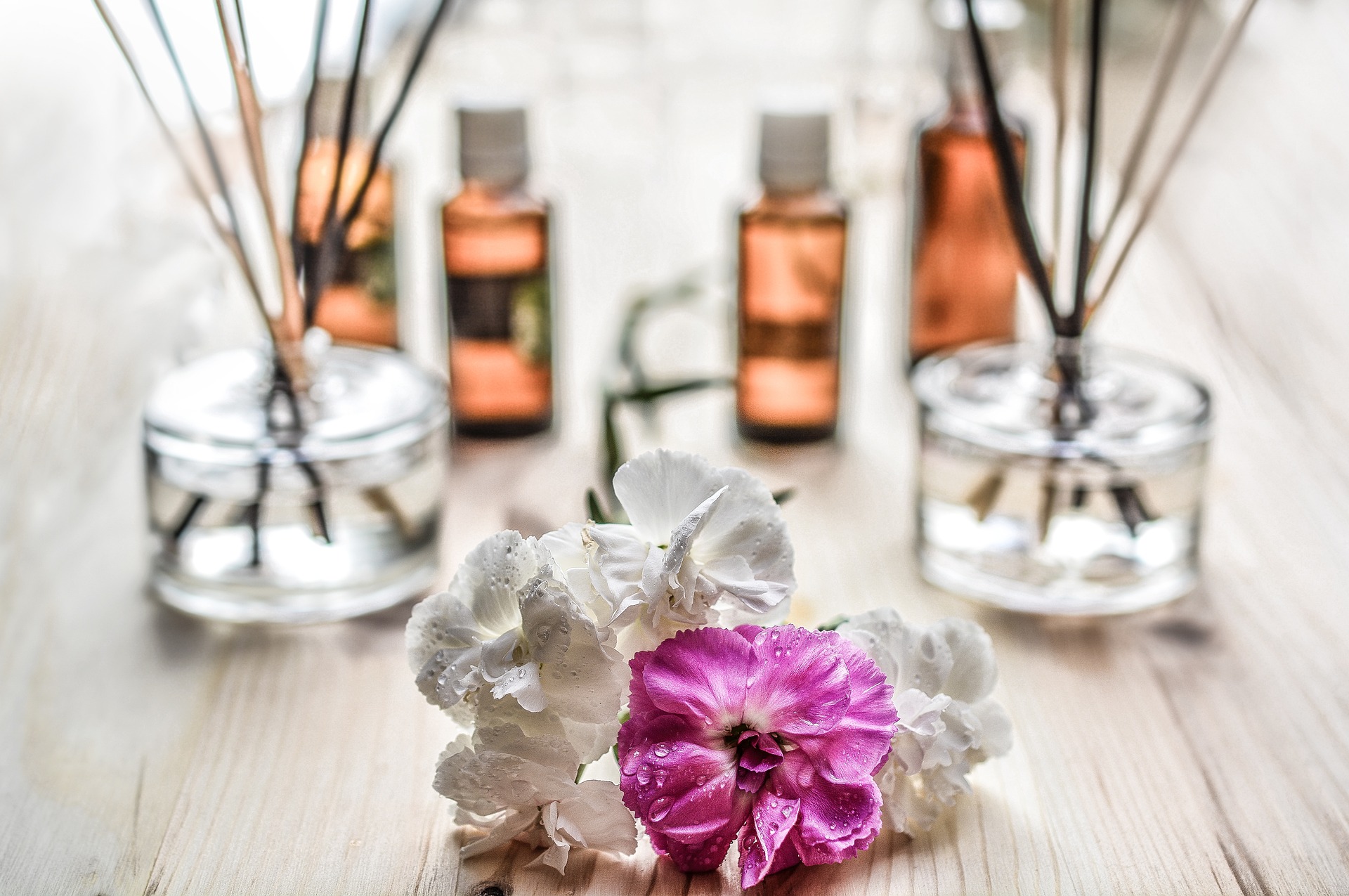Decor with Reed diffusers and flowers on a wooden table.