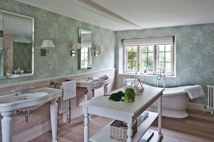 A French country bathroom with blue wallpaper and white sinks.