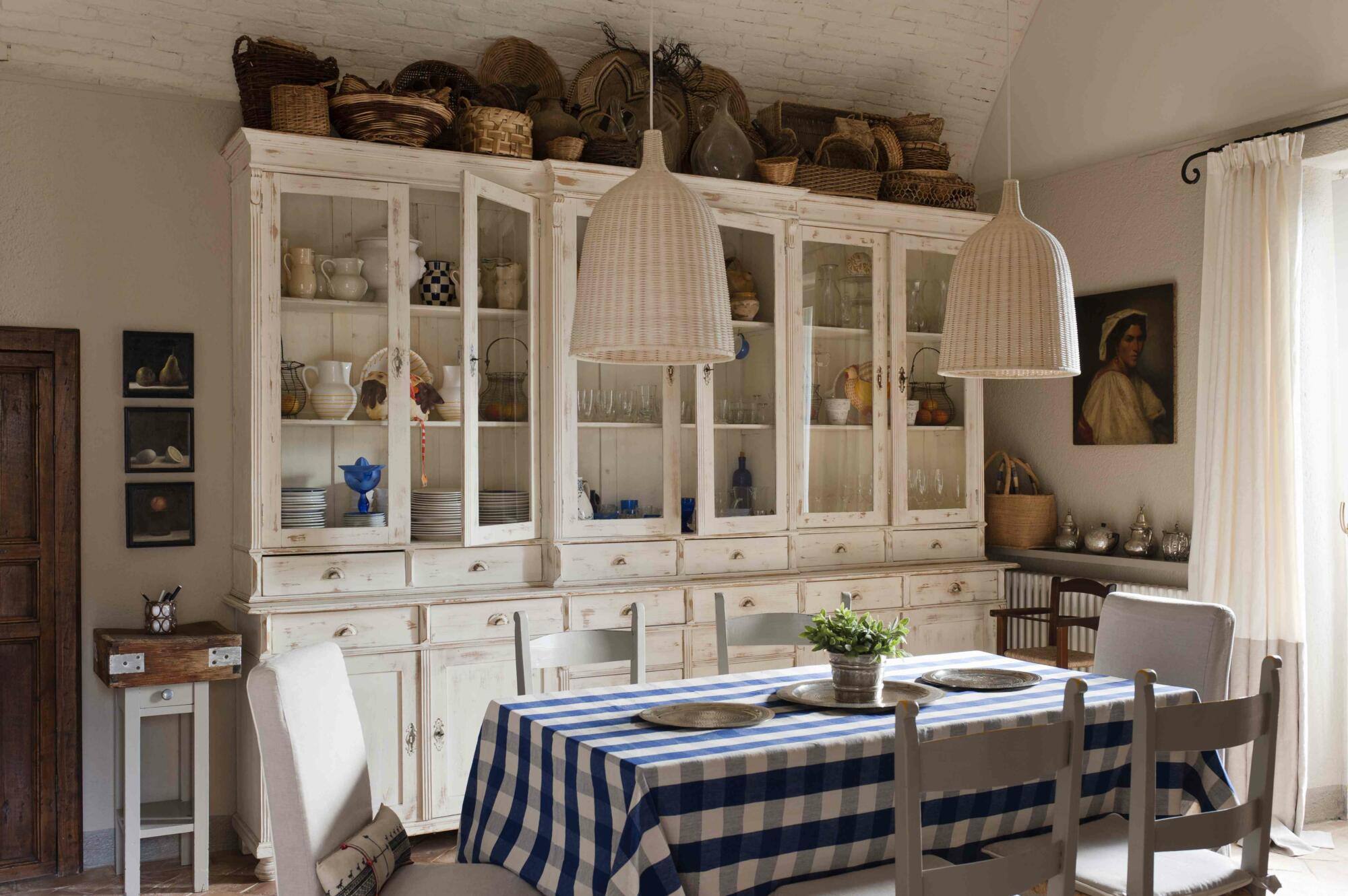 A built-in dining room cabinet with a blue and white checkered tablecloth.