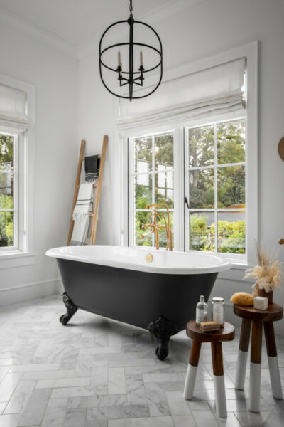 A black and white French country bathroom with a bathtub.