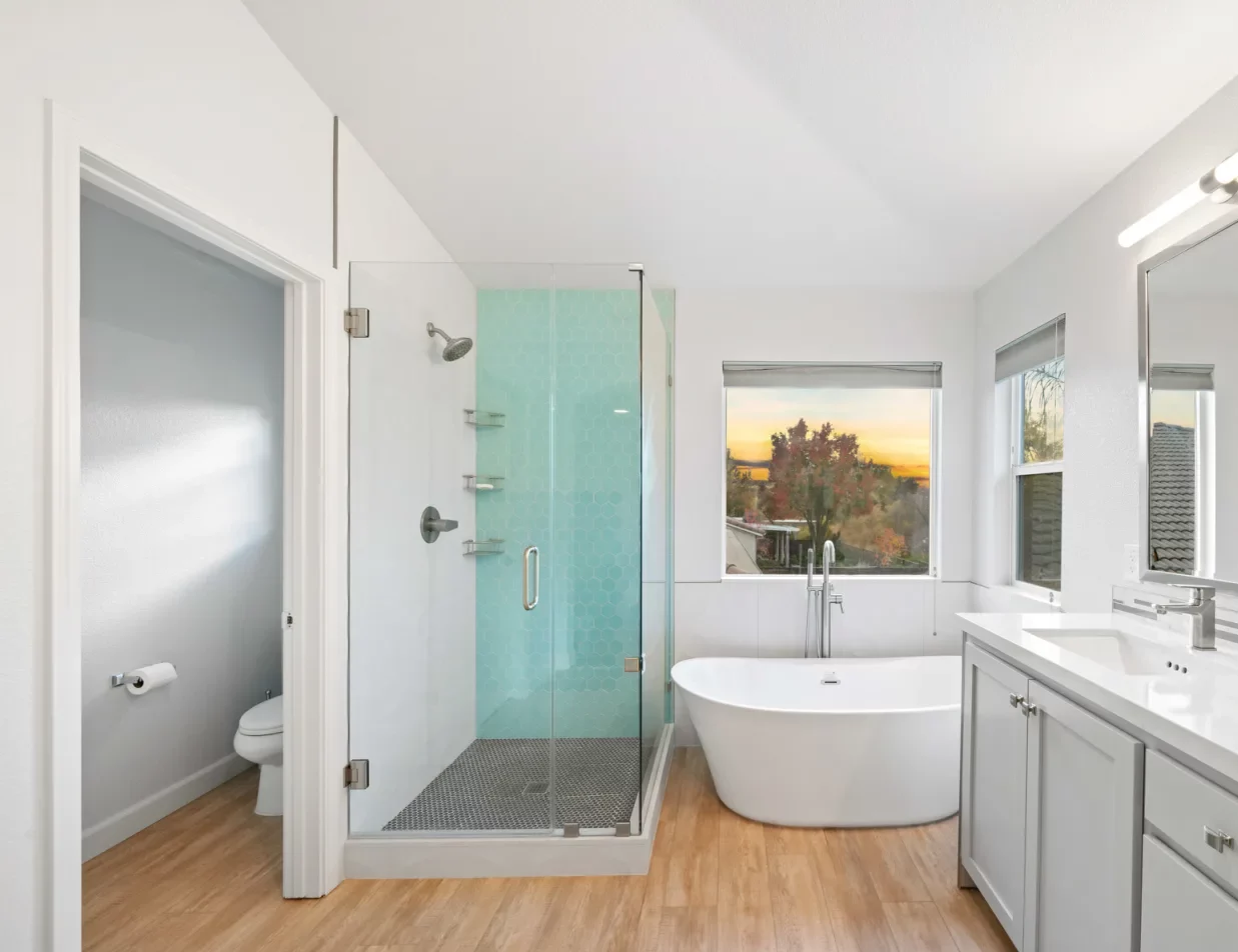 A bathroom with a bathtub, sink and shower that requires a shower remodel.