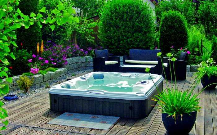 A summer housing project featuring a hot tub on a wooden deck.