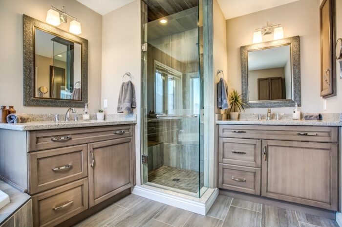A bathroom with two sinks and a walk-in shower with an affordable remodeling cost.