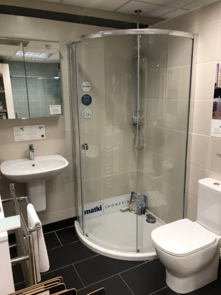 bathroom with a shower wall and a person considering budget considerations