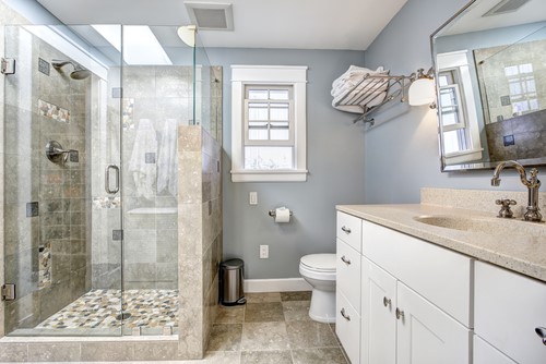 A bathroom featuring a glass shower stall and sink with low maintenance shower walls.