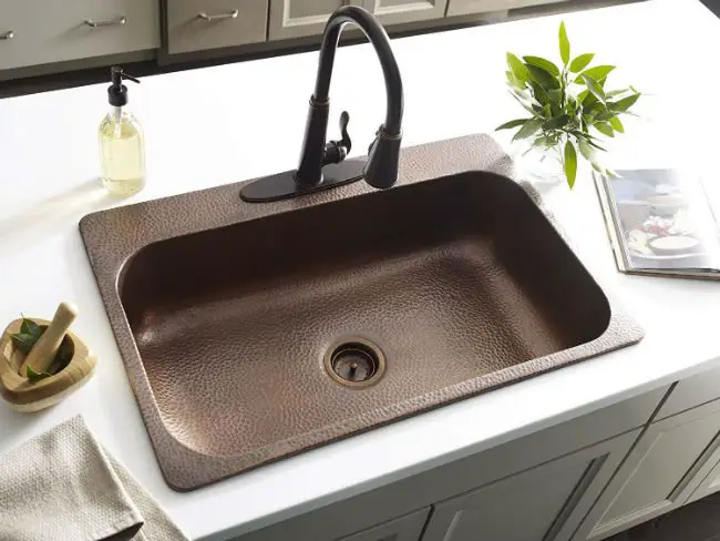 An image of a modern kitchen sink with a black faucet.