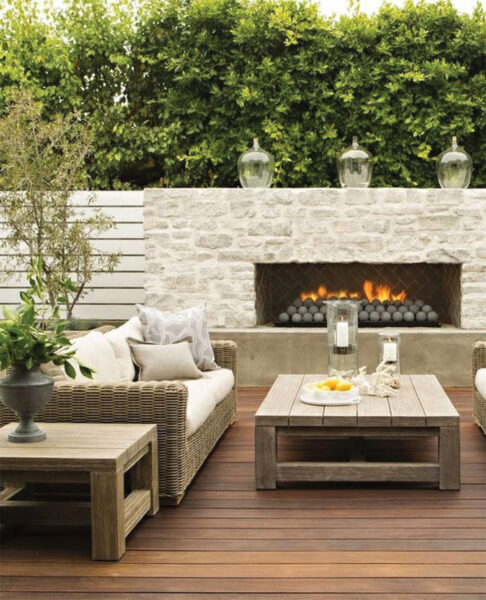An outdoor living area with a fire pit and wicker furniture.
