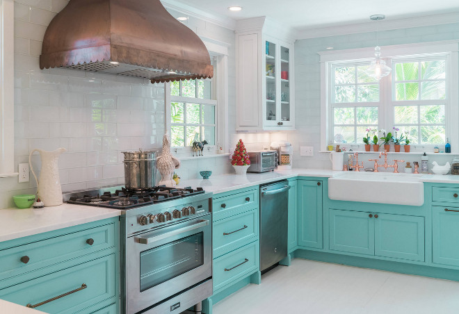 A kitchen with turquoise cabinets and a copper hood.
