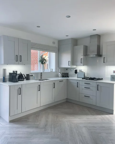 A white kitchen with light gray cabinets.