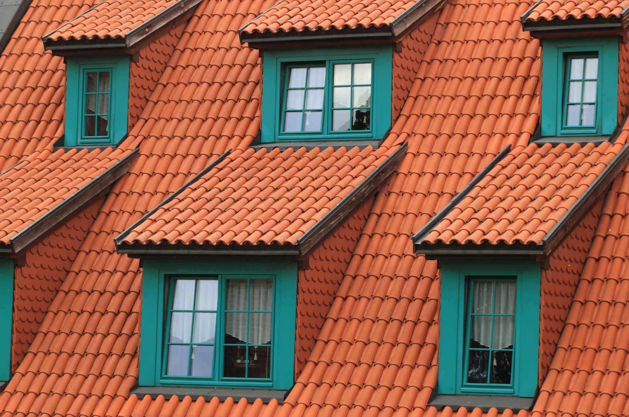 Strengthening Your Roof with Orange Tiled and Green Window Renovations.