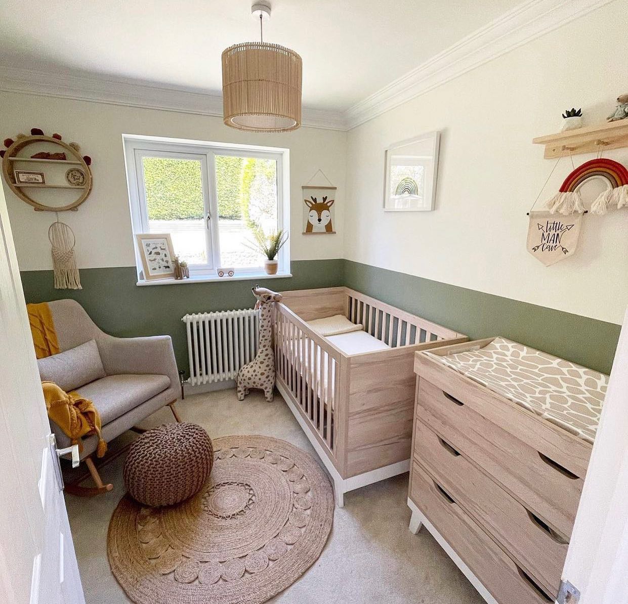 A sage green nursery with a crib and dresser.