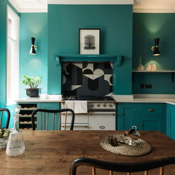 A kitchen with teal walls and turquoise kitchen cabinets.