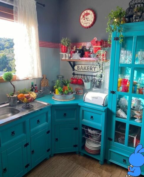 A kitchen with turquoise cabinets and a blue sink.