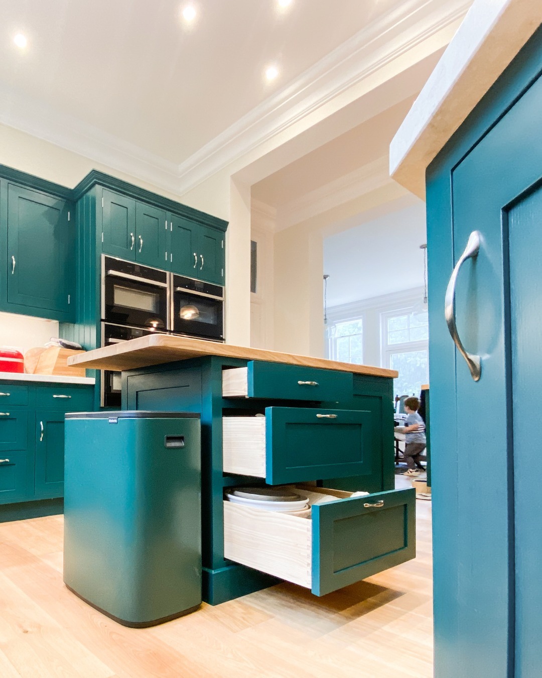 A teal kitchen with wooden floors.