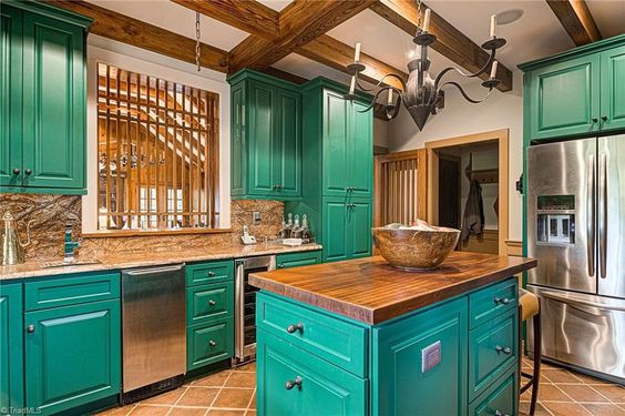 A kitchen with green cabinets.
