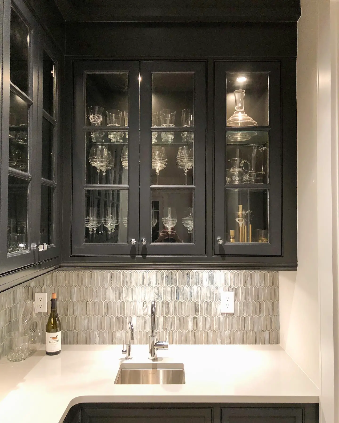 A kitchen with glass cabinets and a sink