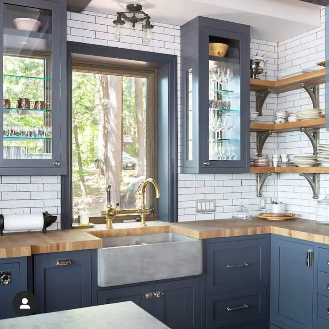 A kitchen with blue cabinets and a wooden sink.