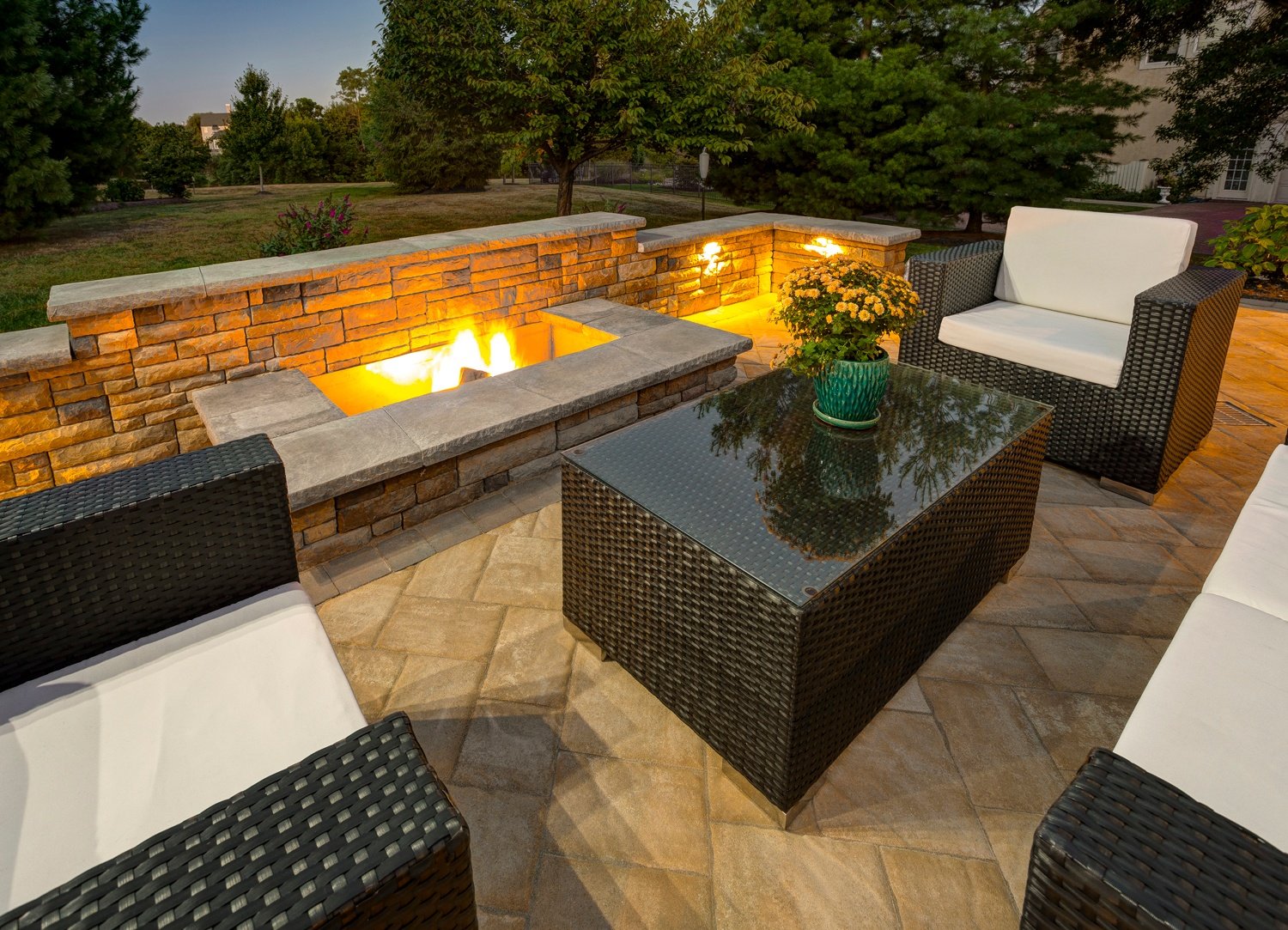 A patio with wicker furniture and a fire pit for outdoor relaxation.