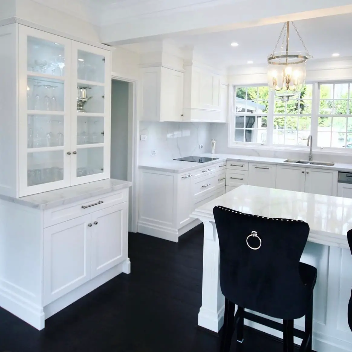 A white kitchen with black counter tops.