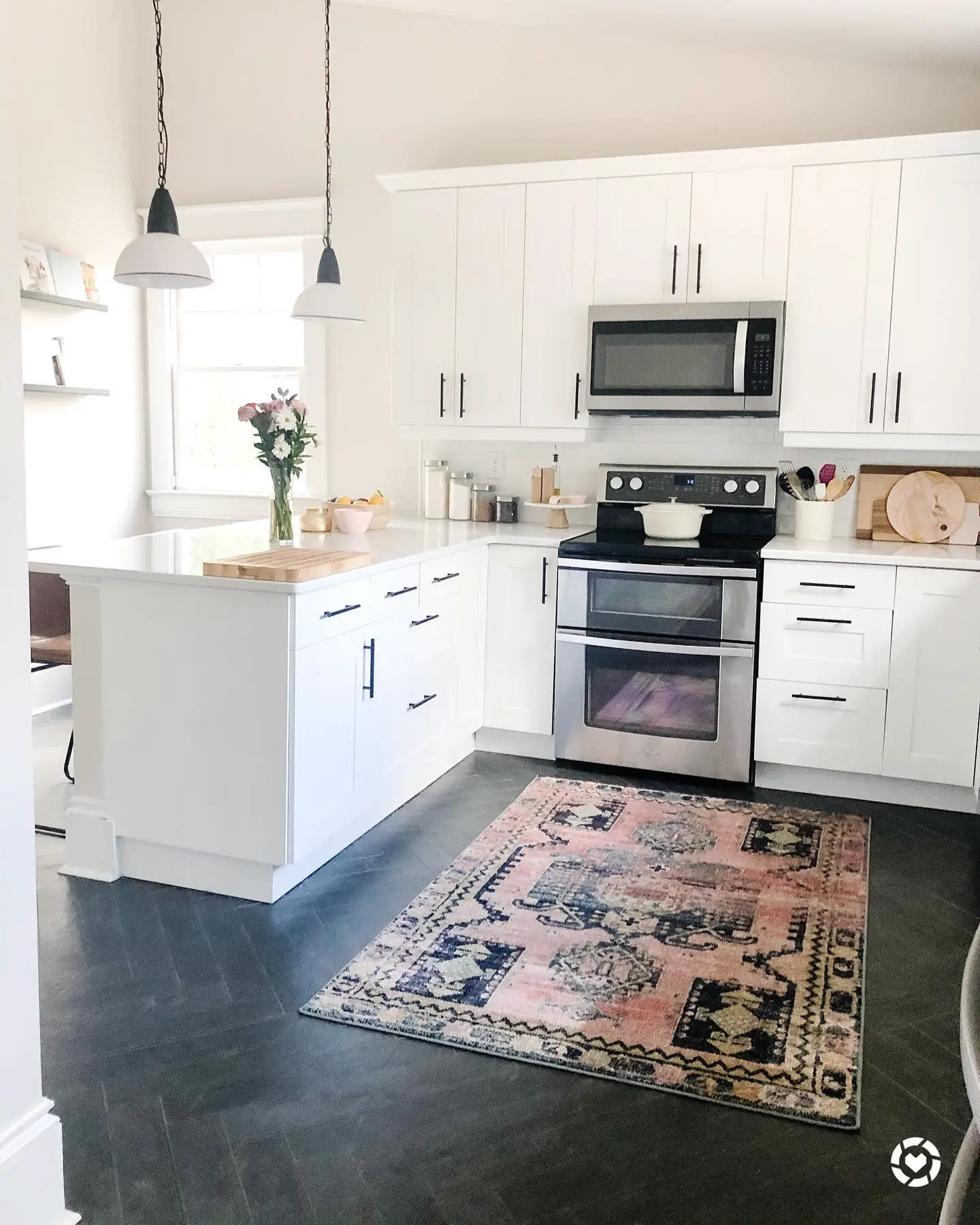 A kitchen with white cabinets and a rug on the floor. (Keywords: White Cabinets, Rug)