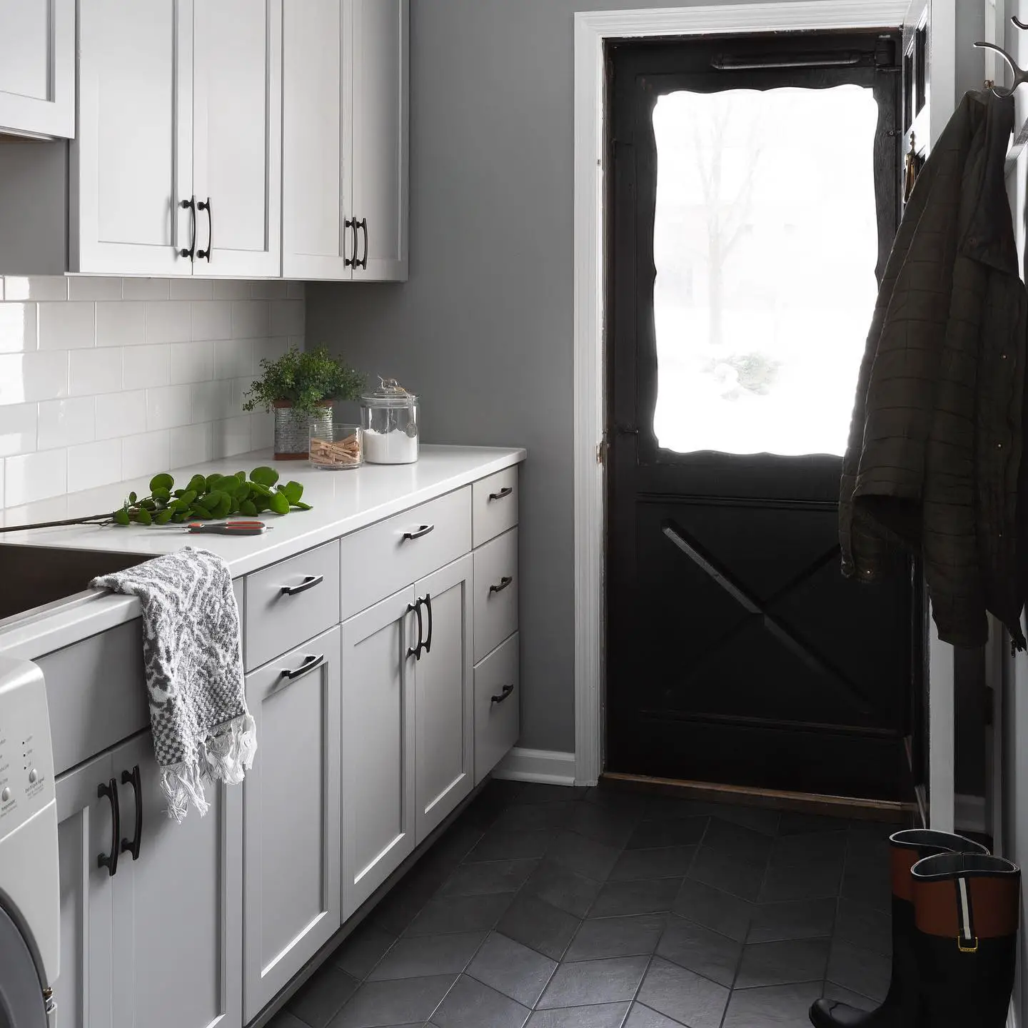 A laundry room with black door.