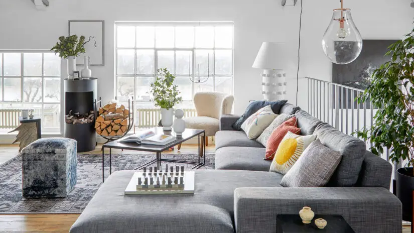 A sectional in charcoal gray sits in a modern industrial living room