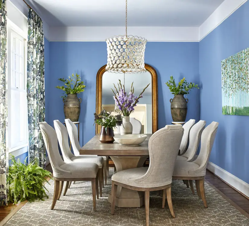 A dining room with blue walls and white furniture.
