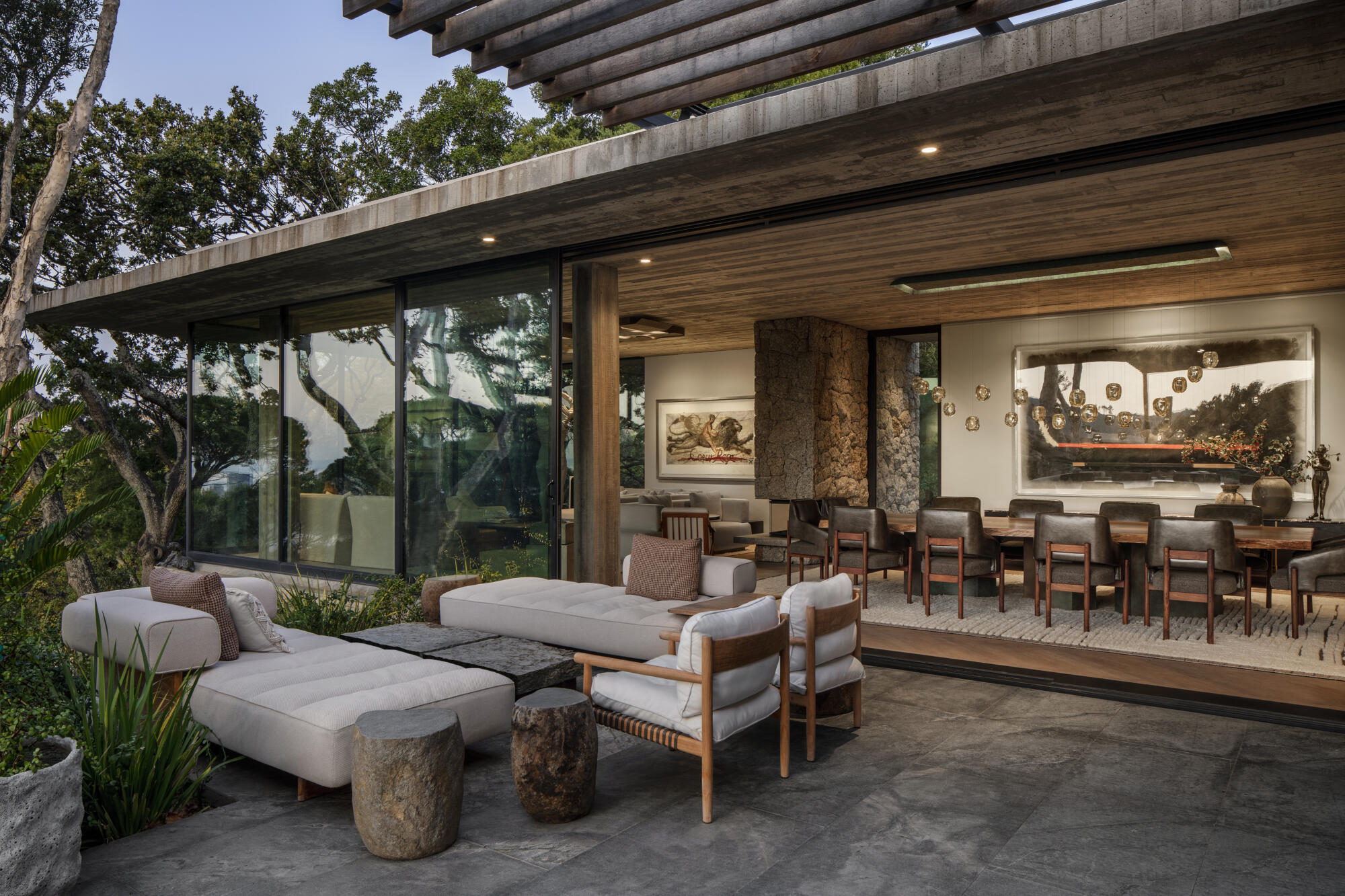 Glen Villa, a contemporary design outdoor living area with a large table and chairs, surrounded by nature's splendor.