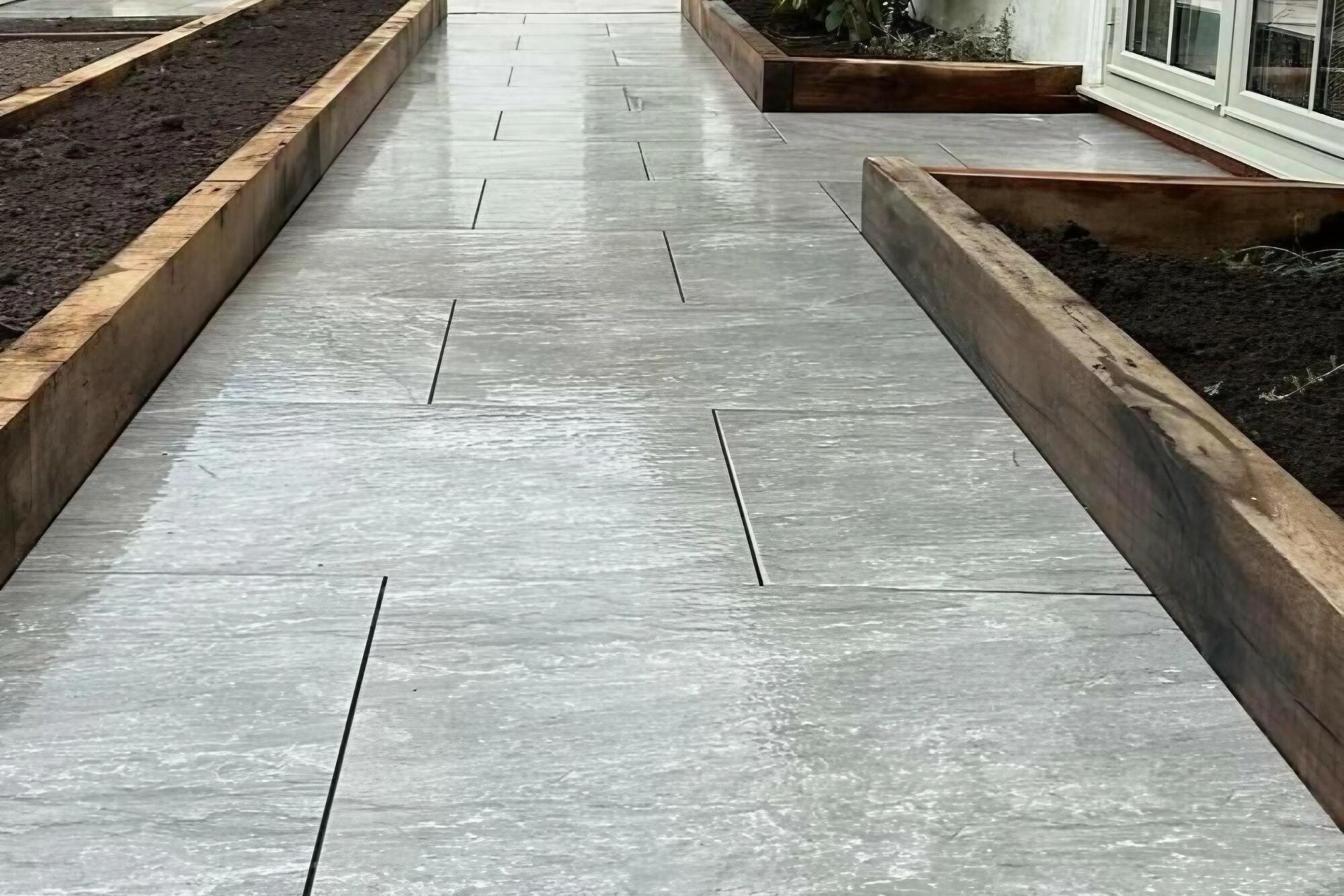 Garden pathway with wooden borders and tiled surface.