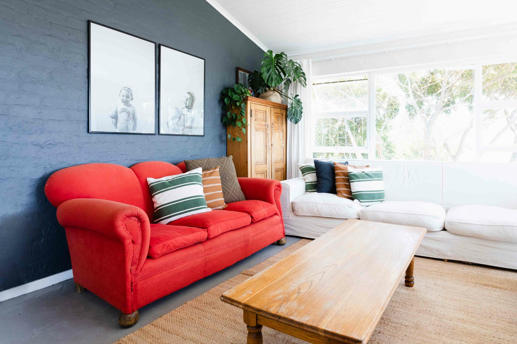 Bright living room with red couch and white sofa