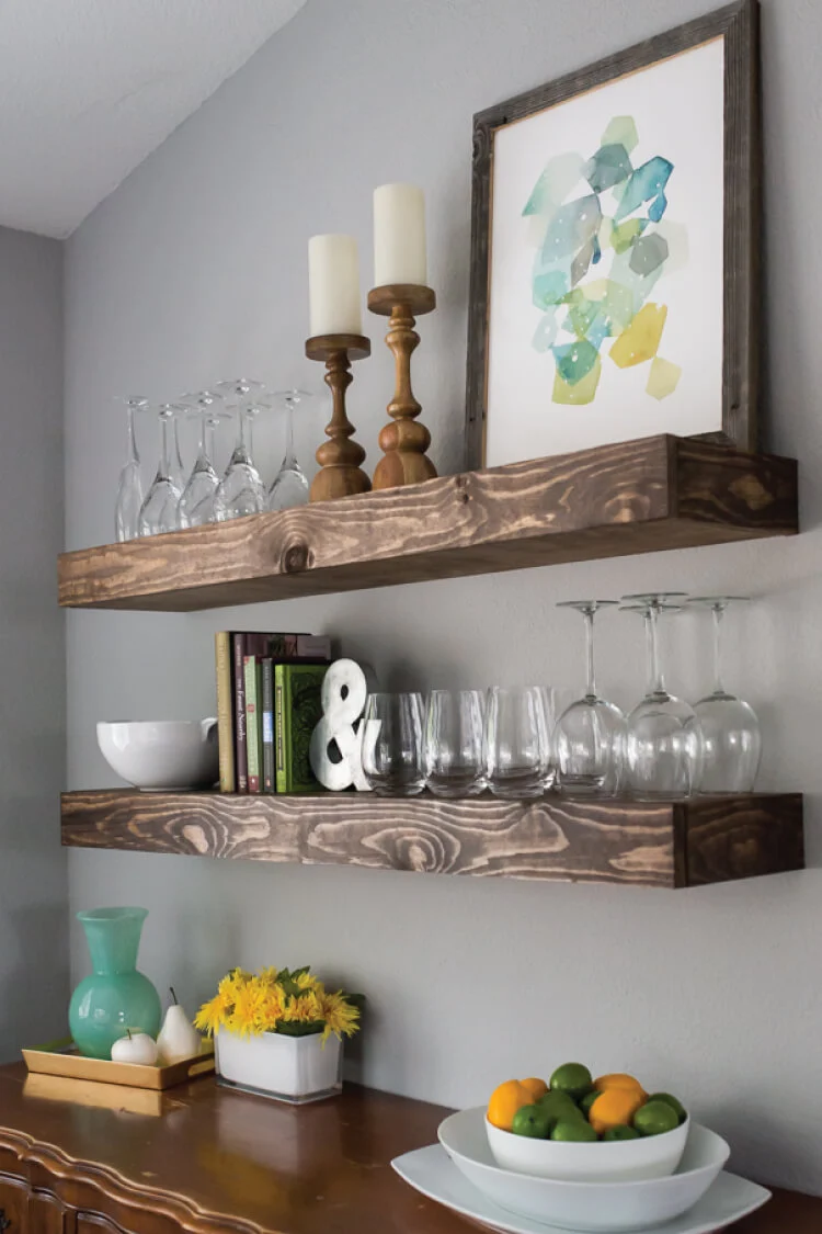 Wooden shelves with decor and glassware in cozy interior.