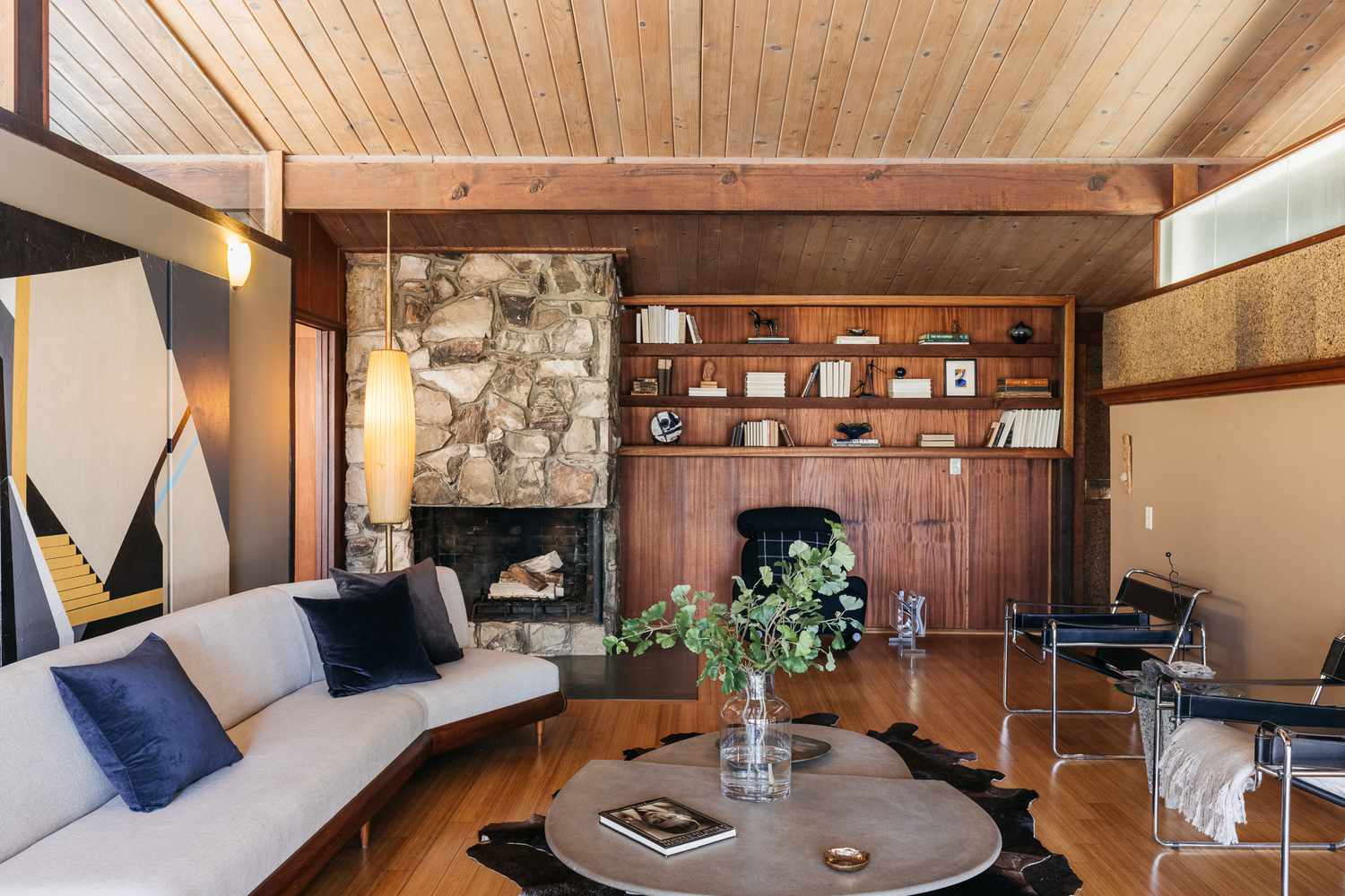 Cozy mid-century modern living room with stone fireplace.