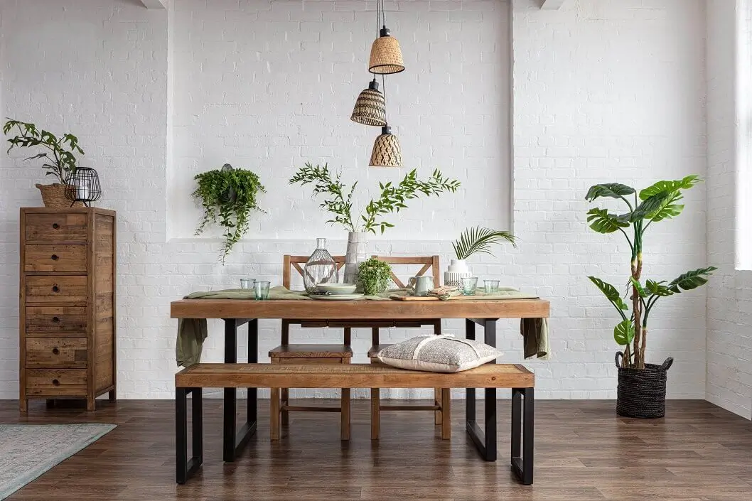 Modern dining room with plants and wooden furniture.