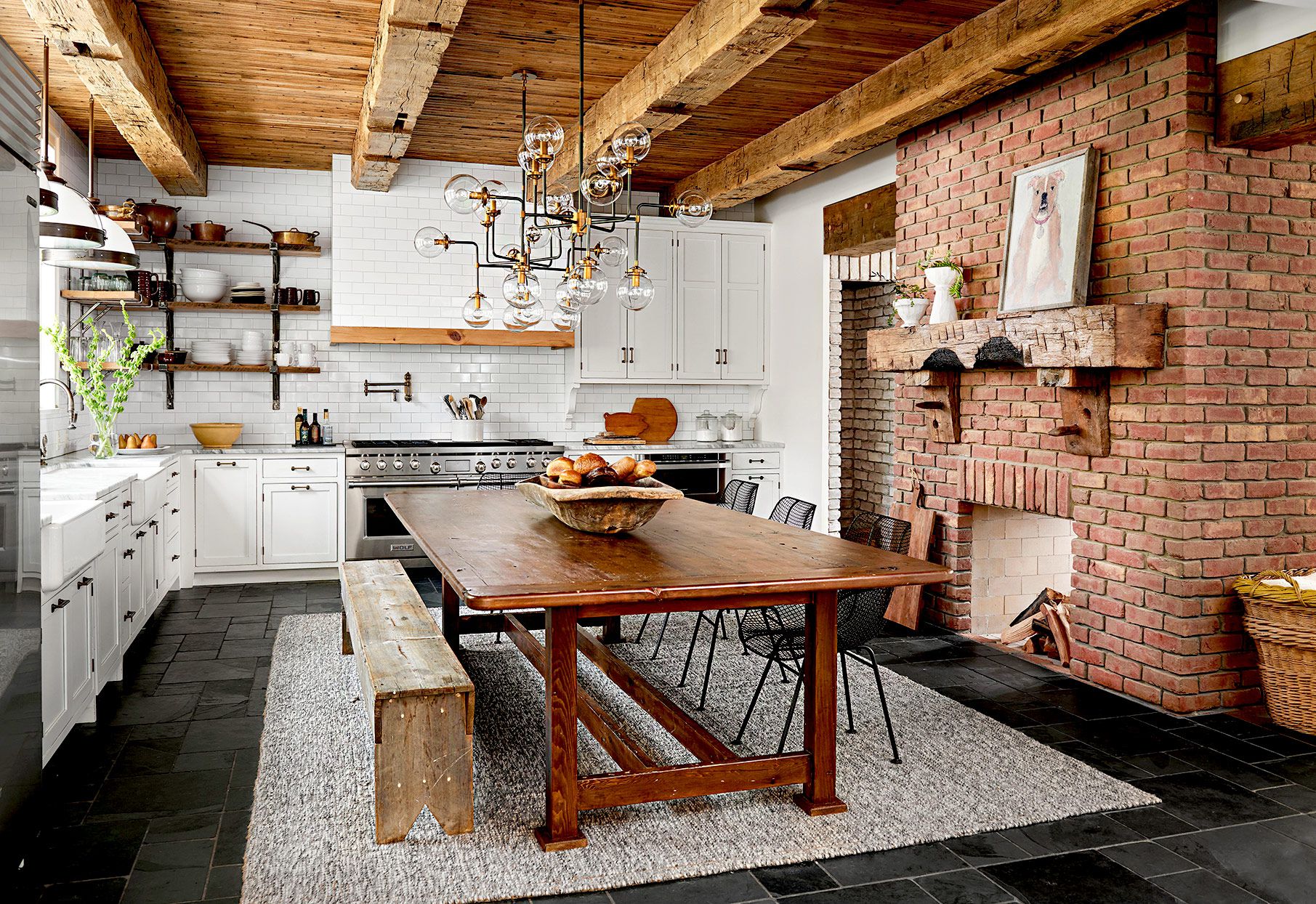Rustic kitchen with brick fireplace and wooden beams.