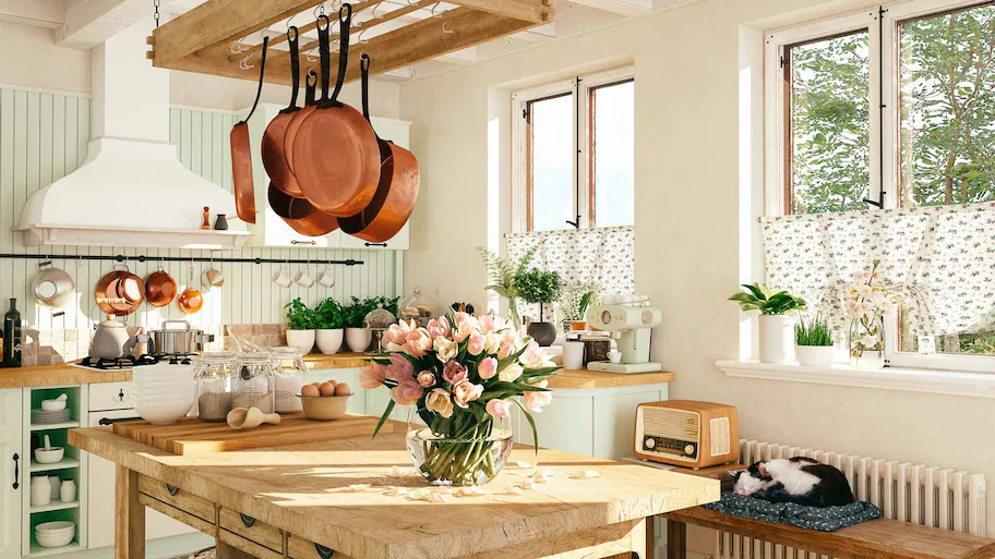 Sunny kitchen interior with copper pots and floral decor.