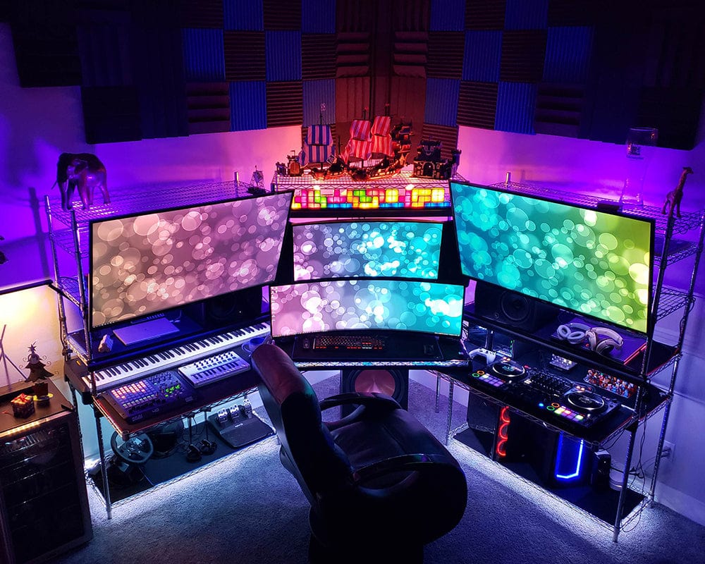 Colorful home music studio with multiple screens and equipment.